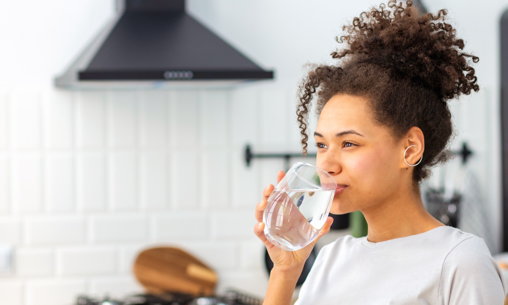 ragazza-in-cucina-che-beve-un-bicchiere-d'acqua