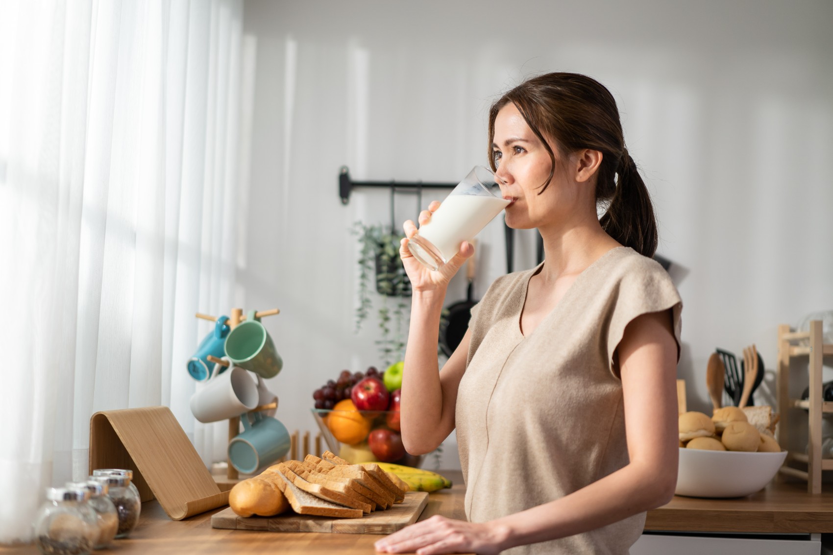 donna-in-cucina-che-beve-una-tazza-di-latte